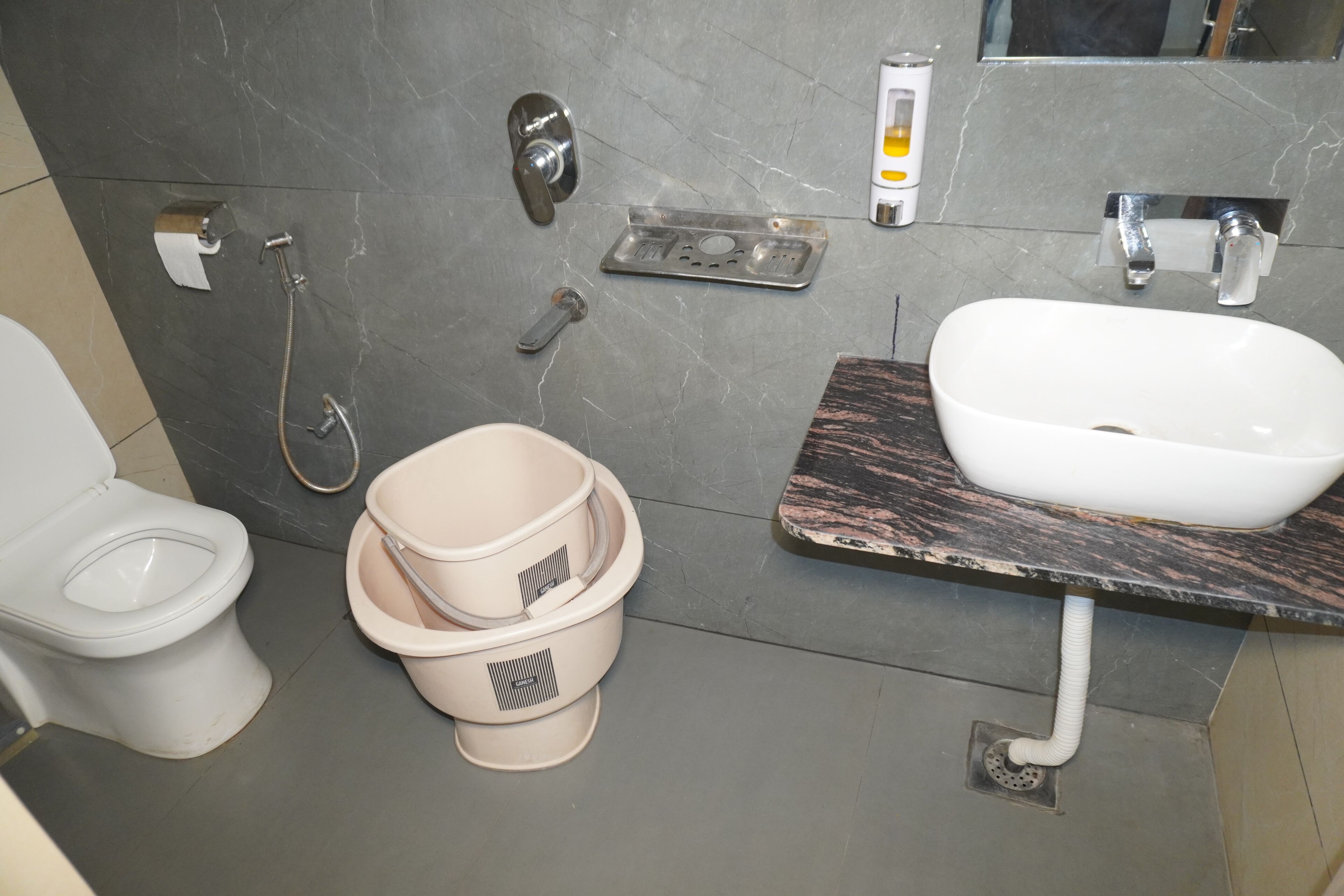 A bathroom with a toilet, bidet, and sink.
