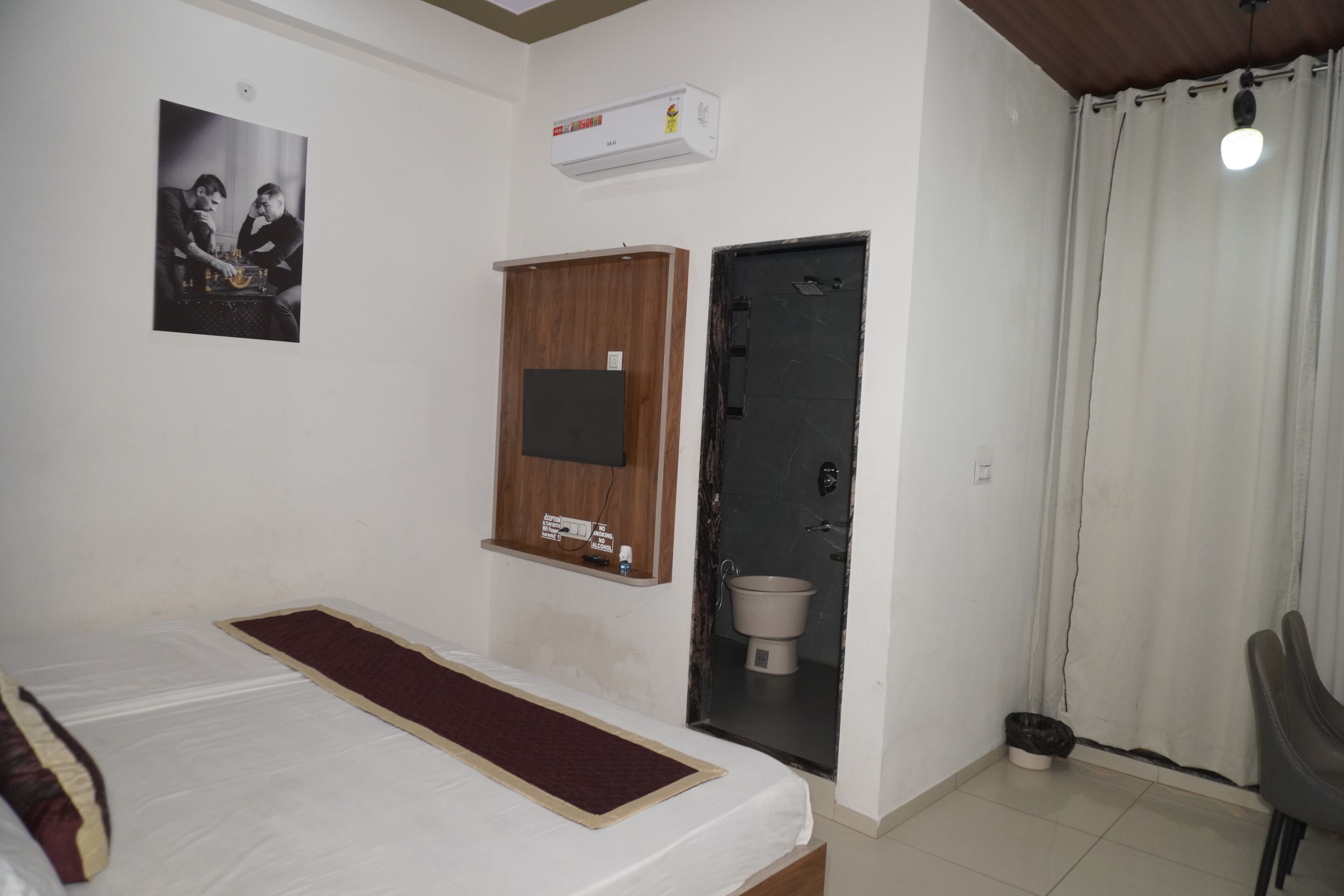 Ein Schlafzimmer mit Bett, Holzschrank, Toilette und Dusche.
