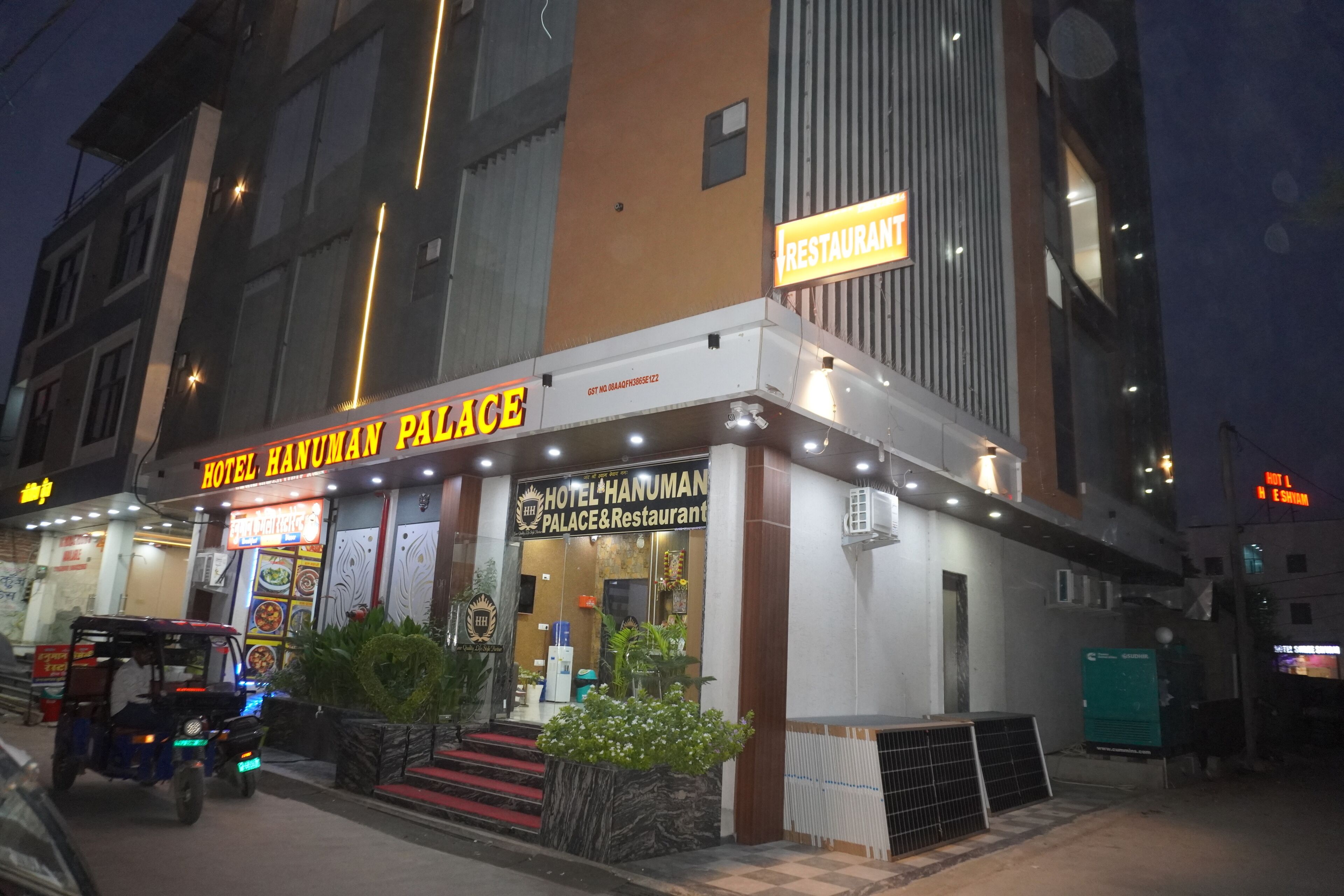 Un hotel chiamato 'Hotel Hanuman Palace' con un cartello che indica un ristorante sopra l'ingresso.
