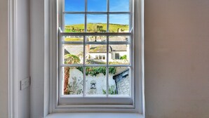 A window with a view of a town, including buildings and a hill. - Apartment in Pickering by Riverside Views (Kingsand)