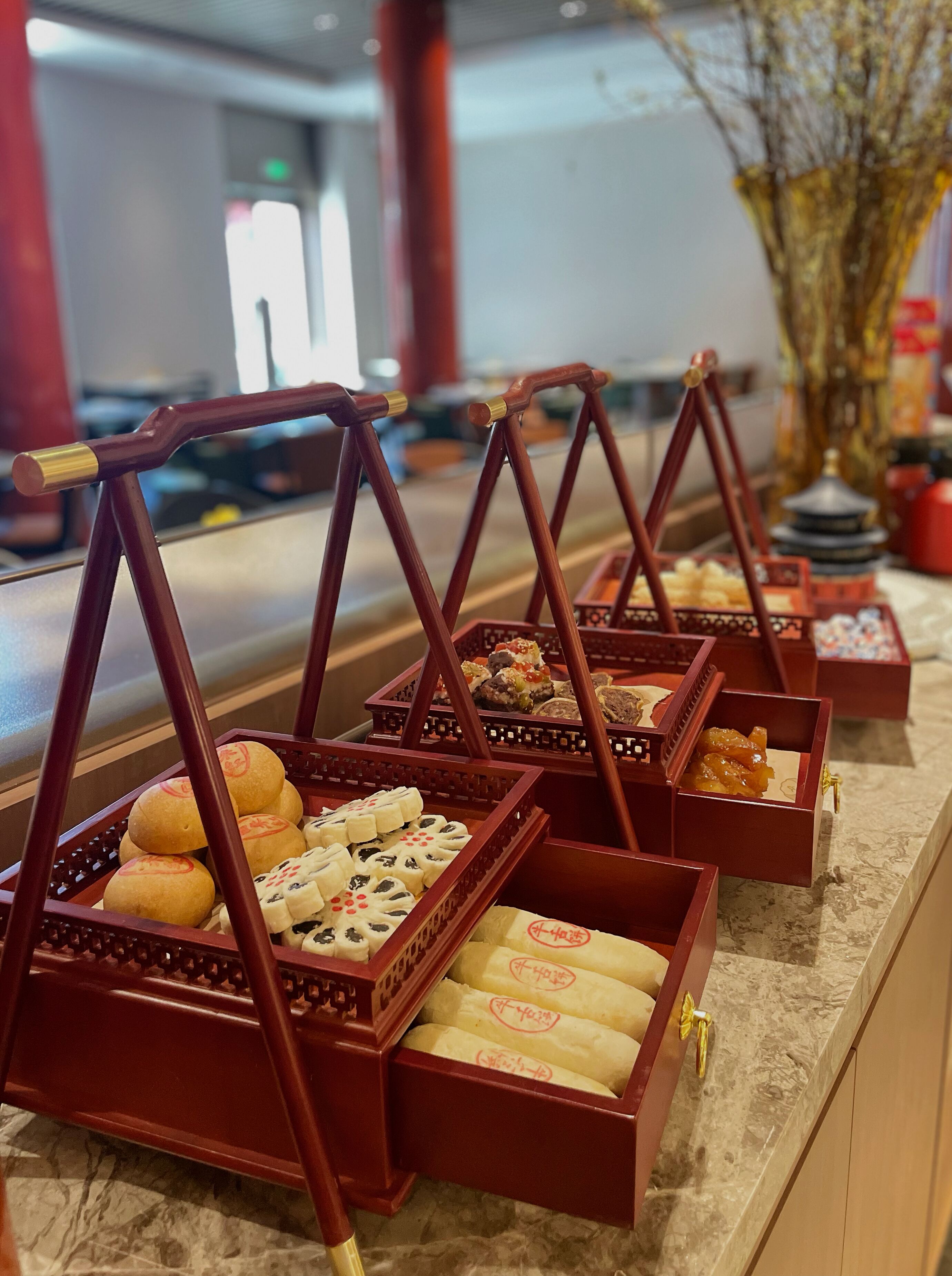 A buffet with various food items in traditional wooden chafing dishes.