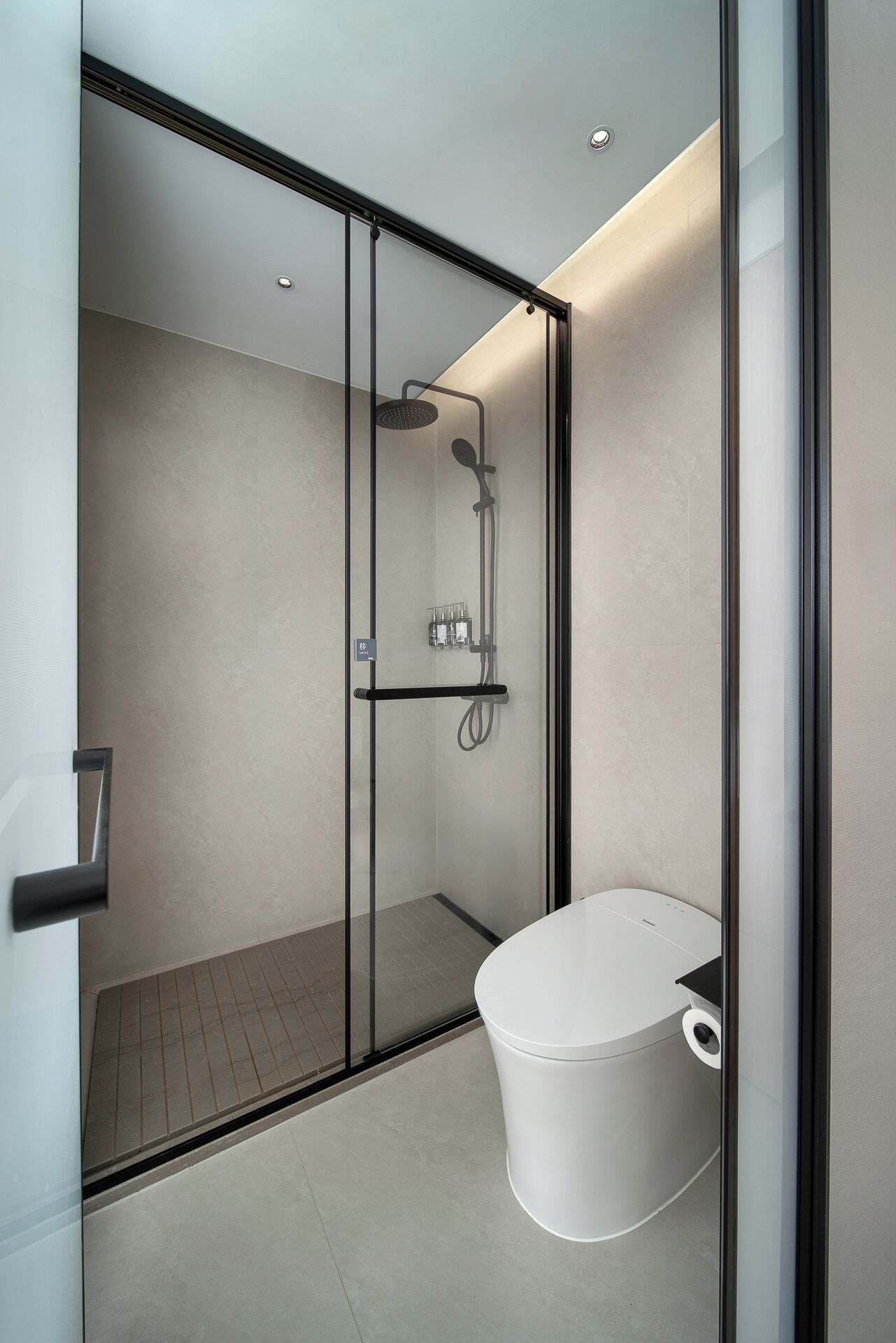 Un baño moderno con ducha acristalada, inodoro y lavabo.