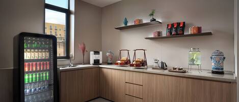 A modern kitchen with a built-in refrigerator, wooden cabinets, and a window providing a view of the outside.