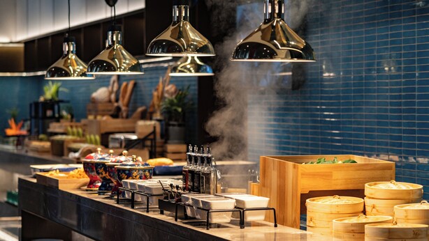 A buffet setup with various food containers, a coffee station, and a steam vent. - SSAW Garden Hotel Beijing (Beijing)