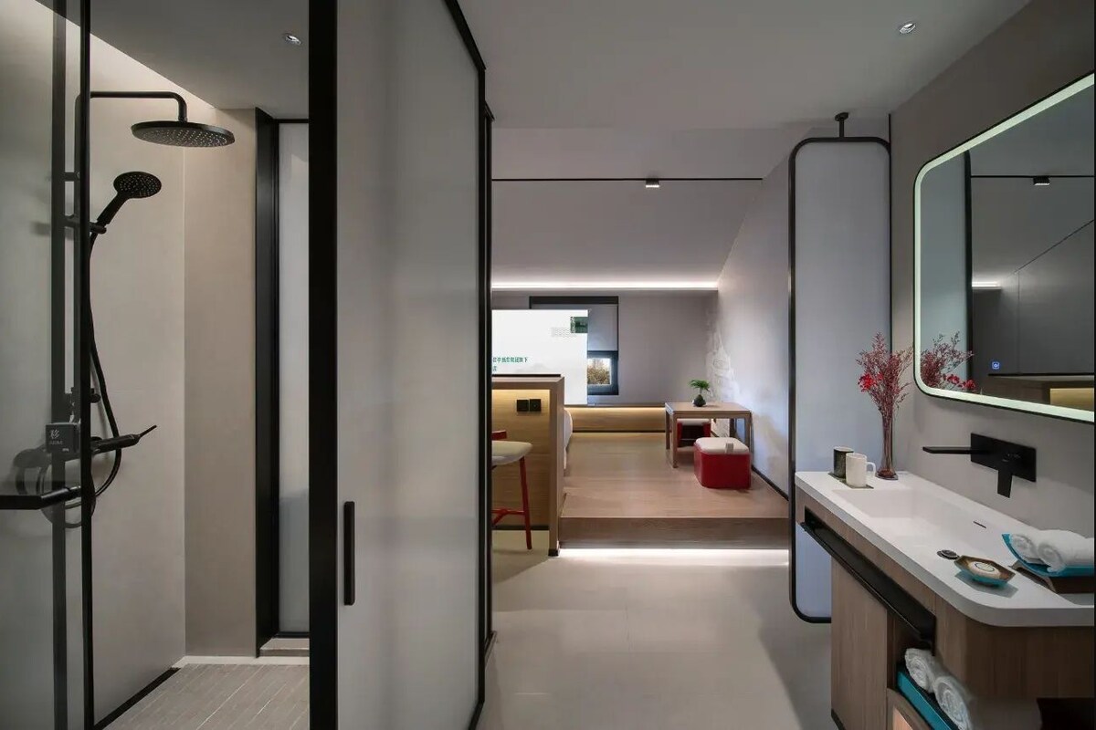 A modern bathroom with a shower, a sink, and a mirror.