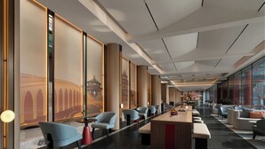 A modern hotel lobby with a long reception desk, seating areas, and large windows offering views of the city. - SSAW Garden Hotel Beijing (Beijing)