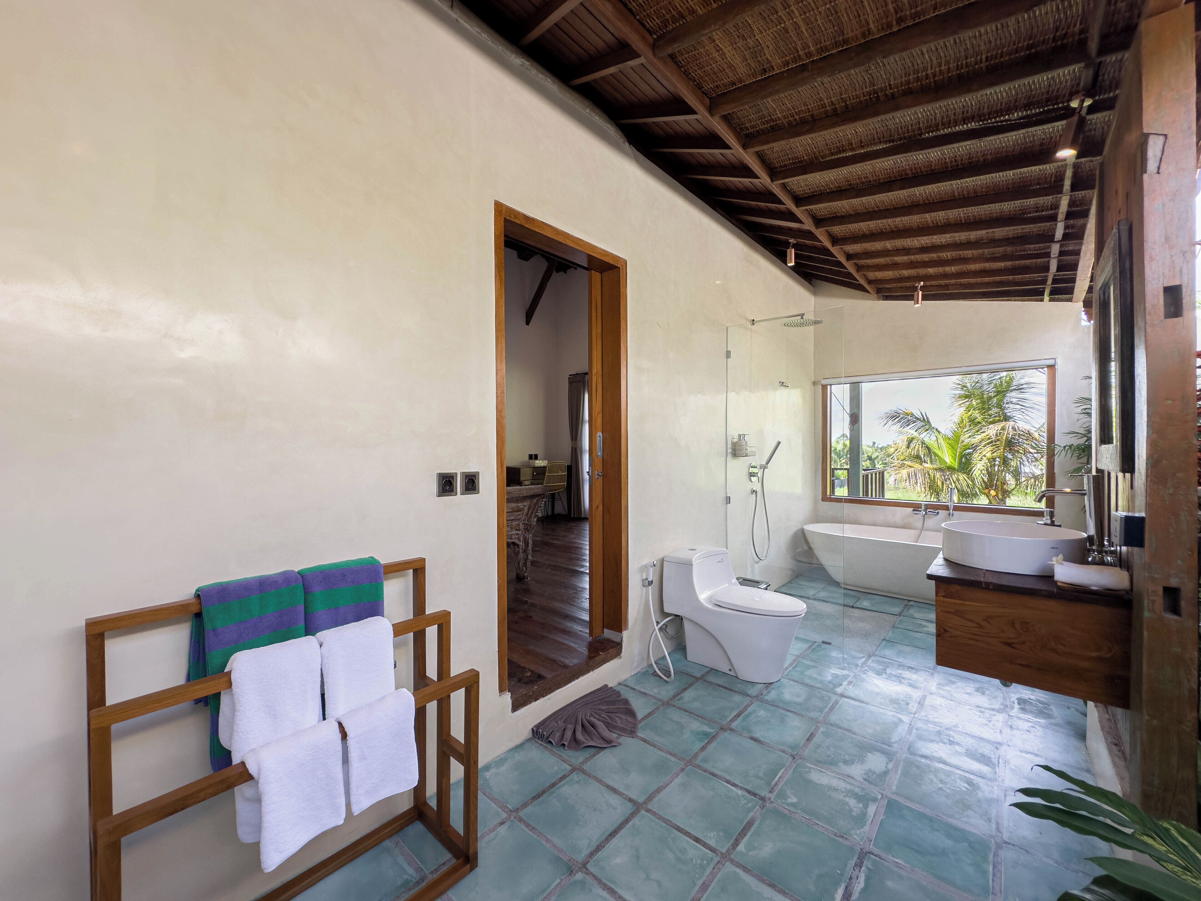 A modern bathroom with a large window, a bathtub, and a shower.