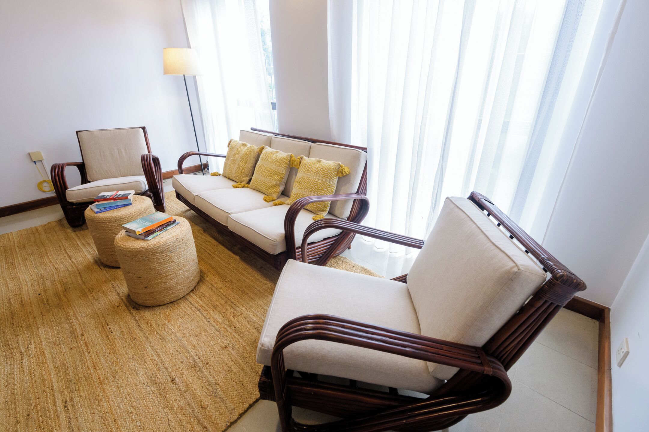 Un salon comprenant un canapé, deux fauteuils, une table basse et une lampe.