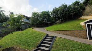 Un quartier résidentiel avec une allée sinueuse, un mur de soutènement en pierre et un escalier menant à une maison.