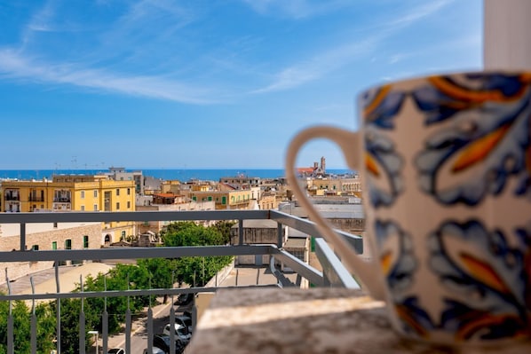 A balcony with a view of a coastal cityscape.