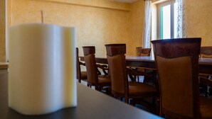 A dining area with a table and chairs, a candle, and a window with curtains. - Sea View Penthouse - Apulia Houses & Flats (Giovinazzo)