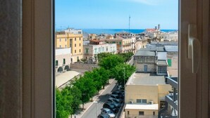 A view through a window of a cityscape with buildings, trees, and a clear sky. - Sea View Penthouse - Apulia Houses & Flats (Giovinazzo)