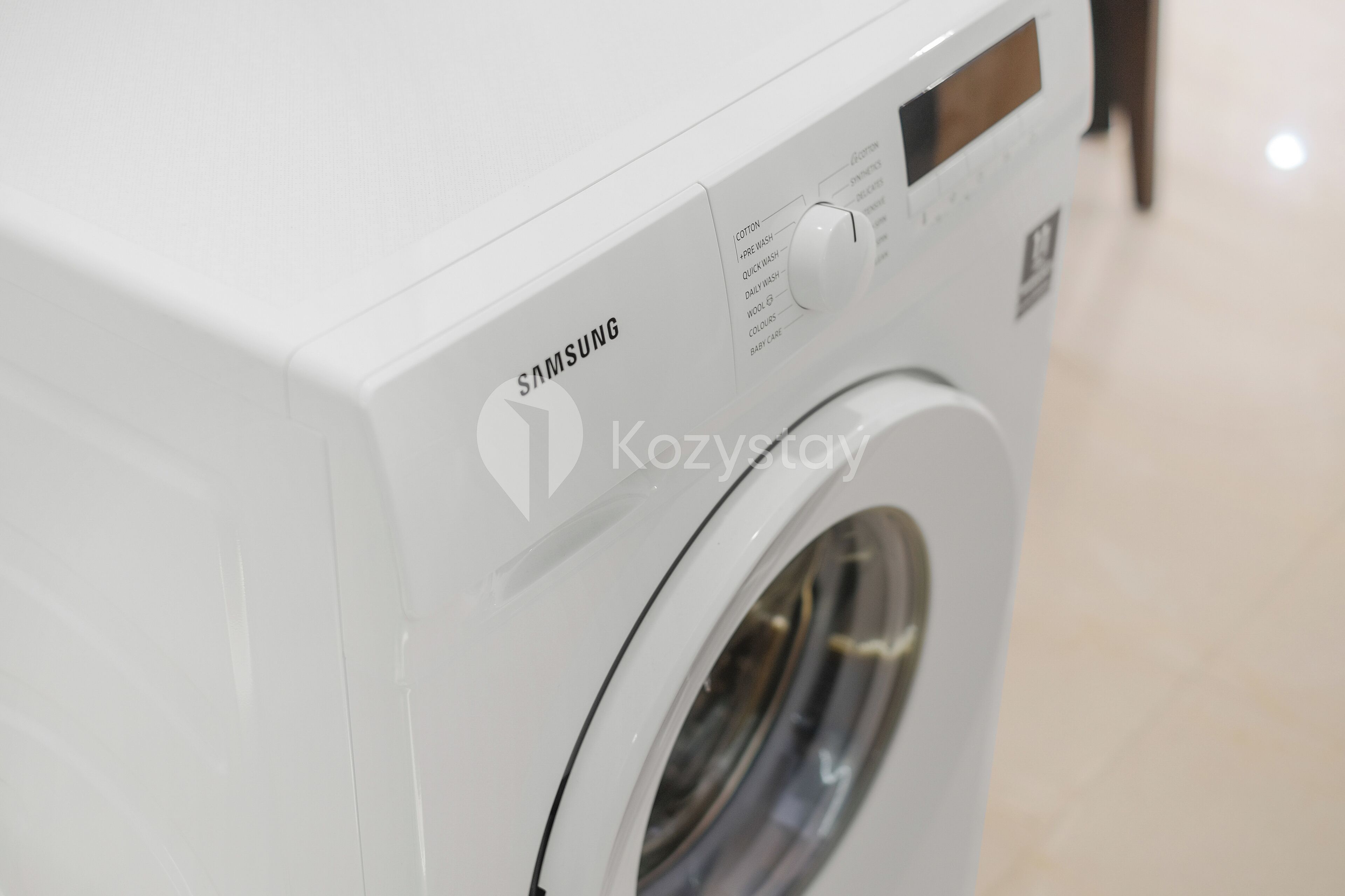 A white Samsung washing machine with a control panel and a transparent door.