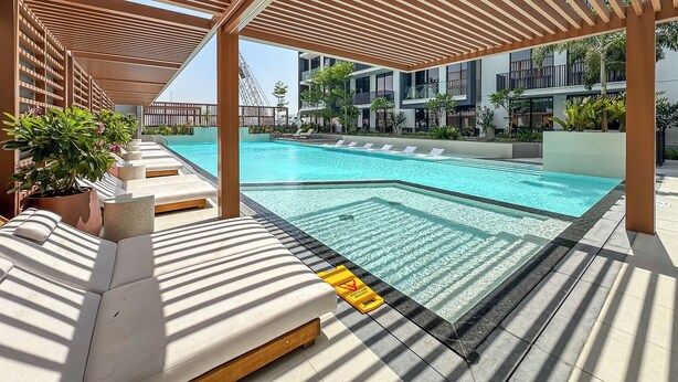 A pool area with lounge chairs and a pergola structure.