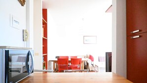 A kitchen with a microwave, a dining table with red chairs, and a red cabinet. - N302 - Numana, three-room apartment with terrace in residence with swimming pool (Nuaman)