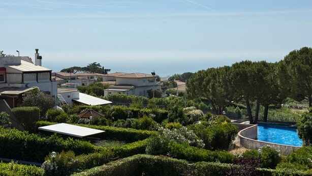 A residential area with a swimming pool surrounded by well-maintained greenery and houses. - N302 - Numana, three-room apartment with terrace in residence with swimming pool (Nuaman)