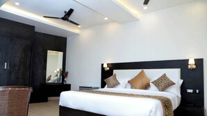 Een moderne hotelkamer met een groot bed, een donker houten hoofdeinde en een plafondventilator.