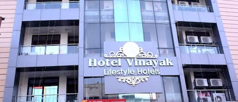 A building with a sign for Hotel Vinayak Lifestyle Hotels.