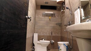 Een badkamer met toilet, wastafel, douche en handdoekhouder.