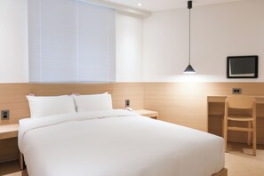A hotel room with a large bed, a desk, a chair, a desk lamp, and a TV on the wall. - HOTEL CARPET (Pocheon)