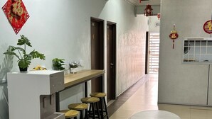 A modern kitchen with a built-in coffee machine, bar stools, and a round table. - Hotel O Kledang Menglembu (Menglembu)