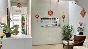 A reception area with a desk, chairs, potted plants, and traditional decorations. - Hotel O Kledang Menglembu (Menglembu)