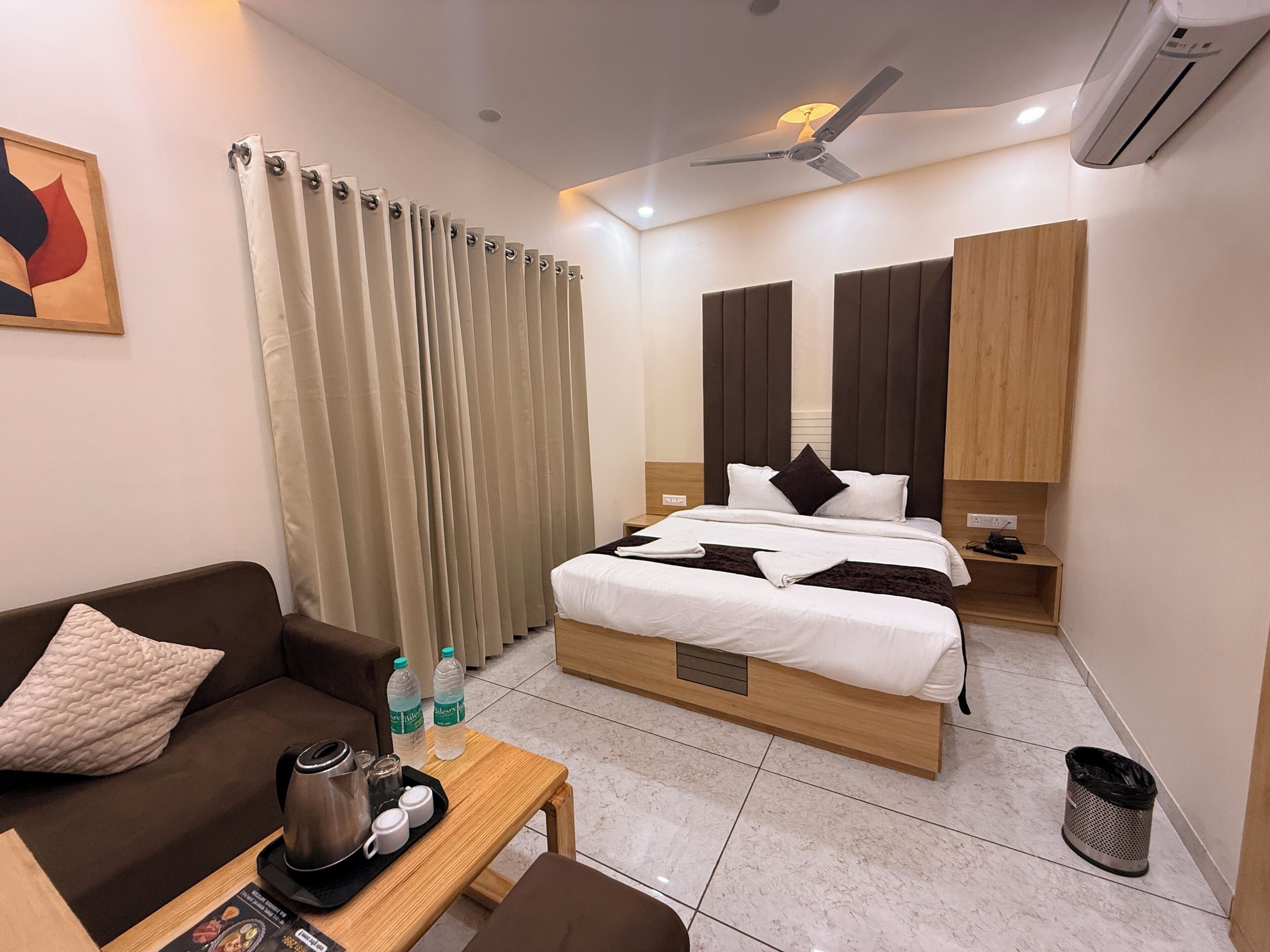 Ein modernes Hotelzimmer mit Bett, Sofa, Couchtisch und Schreibtisch.