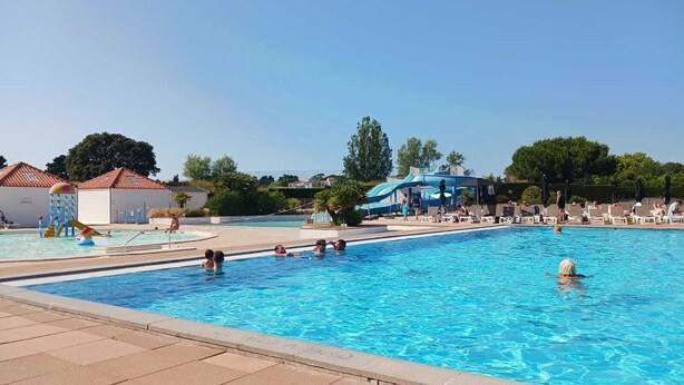 A swimming pool with people, a water slide, and lounge chairs. - Apartment -2 bedrooms, ground floor Port Bourgenay village with swimming pool access (Talmont-Saint-Hilaire)