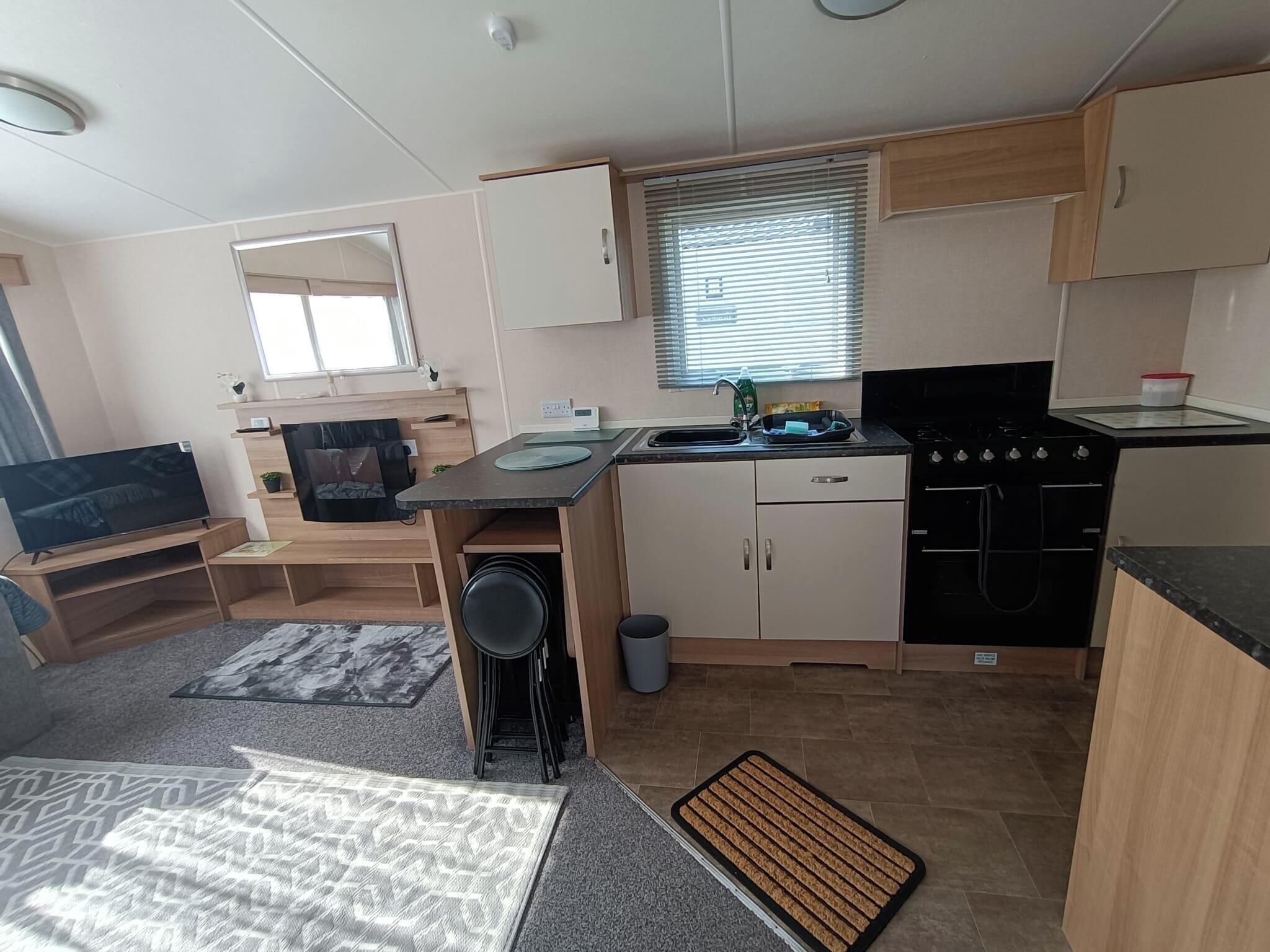 A compact kitchen with a stove, sink, and a small dining area.