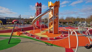 Une aire de jeux avec des structures colorées et un toboggan.