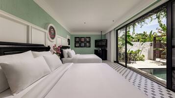 A hotel room with a large bed, two bedside tables, a television, and a view of a pool and outdoor area.