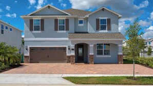 A two-story house with a garage, a front door, and a small porch. - Spacious 8-bedroom apartment with WiFi, fitness room in wonderful Kissimmee (Kissimmee)