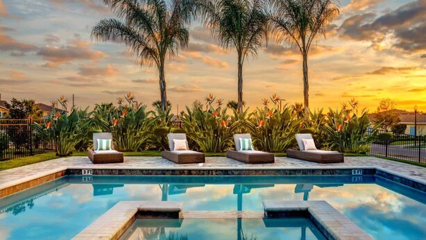 A poolside area with lounge chairs and a clear view of the sunset. - Spacious 8-bedroom apartment with WiFi, fitness room in wonderful Kissimmee (Kissimmee)