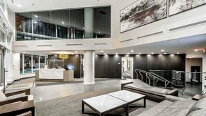 A spacious lobby with a reception desk, seating area, and a staircase leading to an upper level. - Beautiful Downtown Condo- A/C, Parking, Laundry, Great Location! (Vancouver)