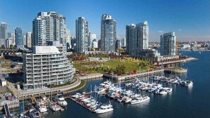 A marina with numerous boats docked, surrounded by high-rise buildings and a waterfront park. - Beautiful Downtown Condo- A/C, Parking, Laundry, Great Location! (Vancouver)