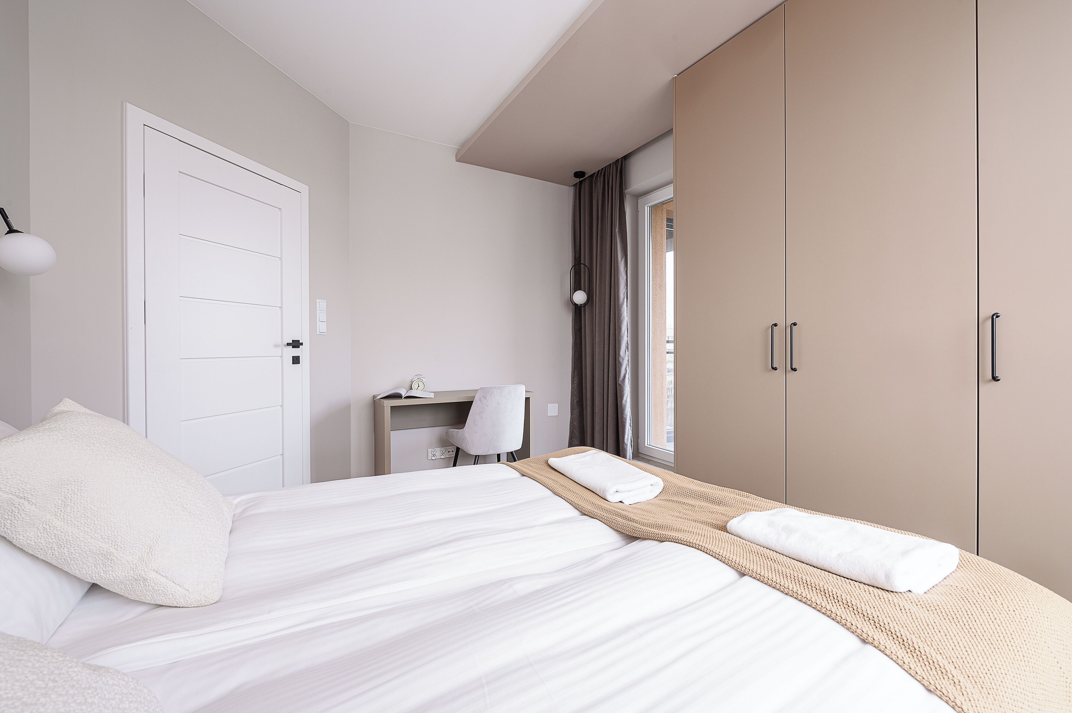 Une chambre d’hôtel équipée d’un lit, d’un bureau, d’une chaise et d’une armoire.