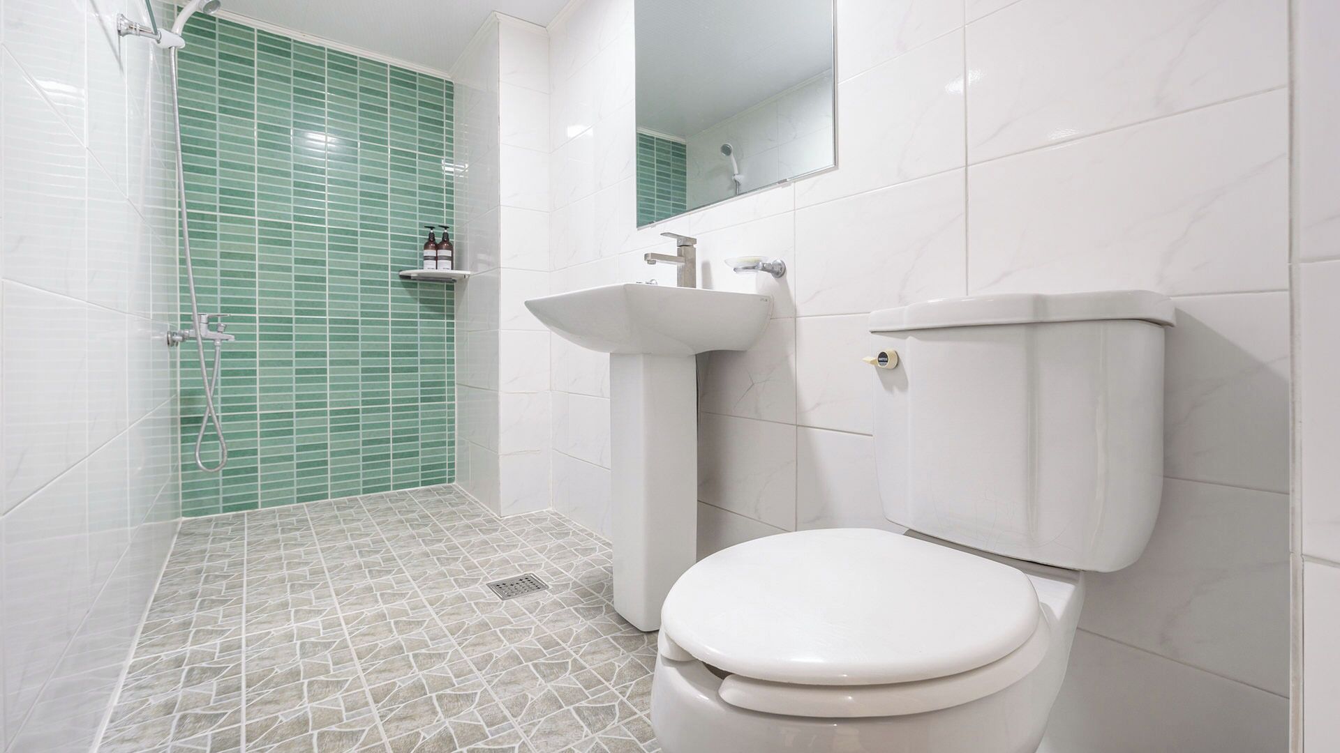 A bathroom with a toilet, sink, and shower area.