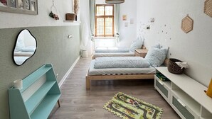 Un dormitorio con cama, un banco, un espejo y una lámpara colgante.