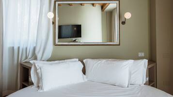 Ein Hotelzimmer mit einem Bett, einem Fernseher und einem Spiegel an der Wand.