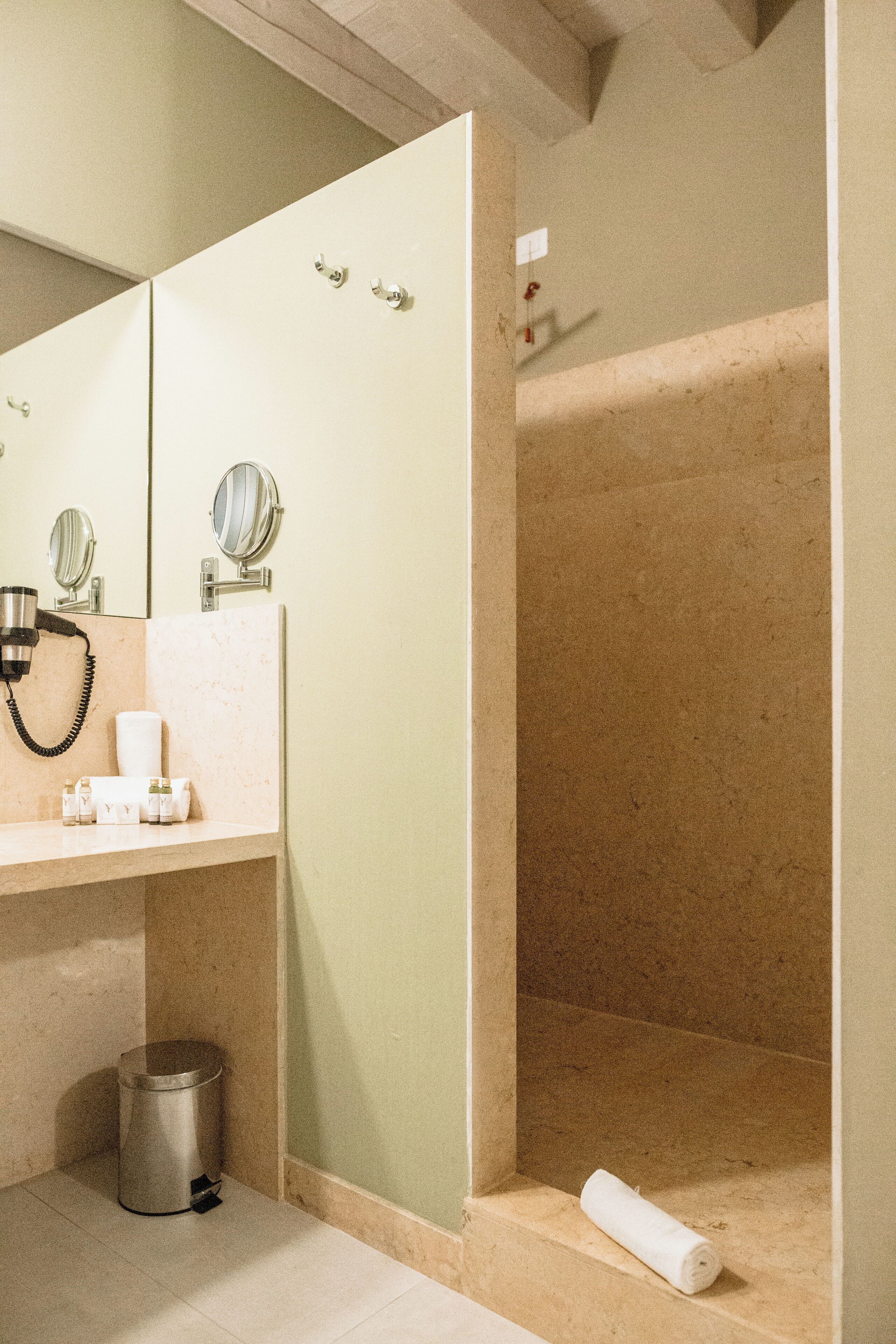 A bathroom with a sink, mirror, and shower.