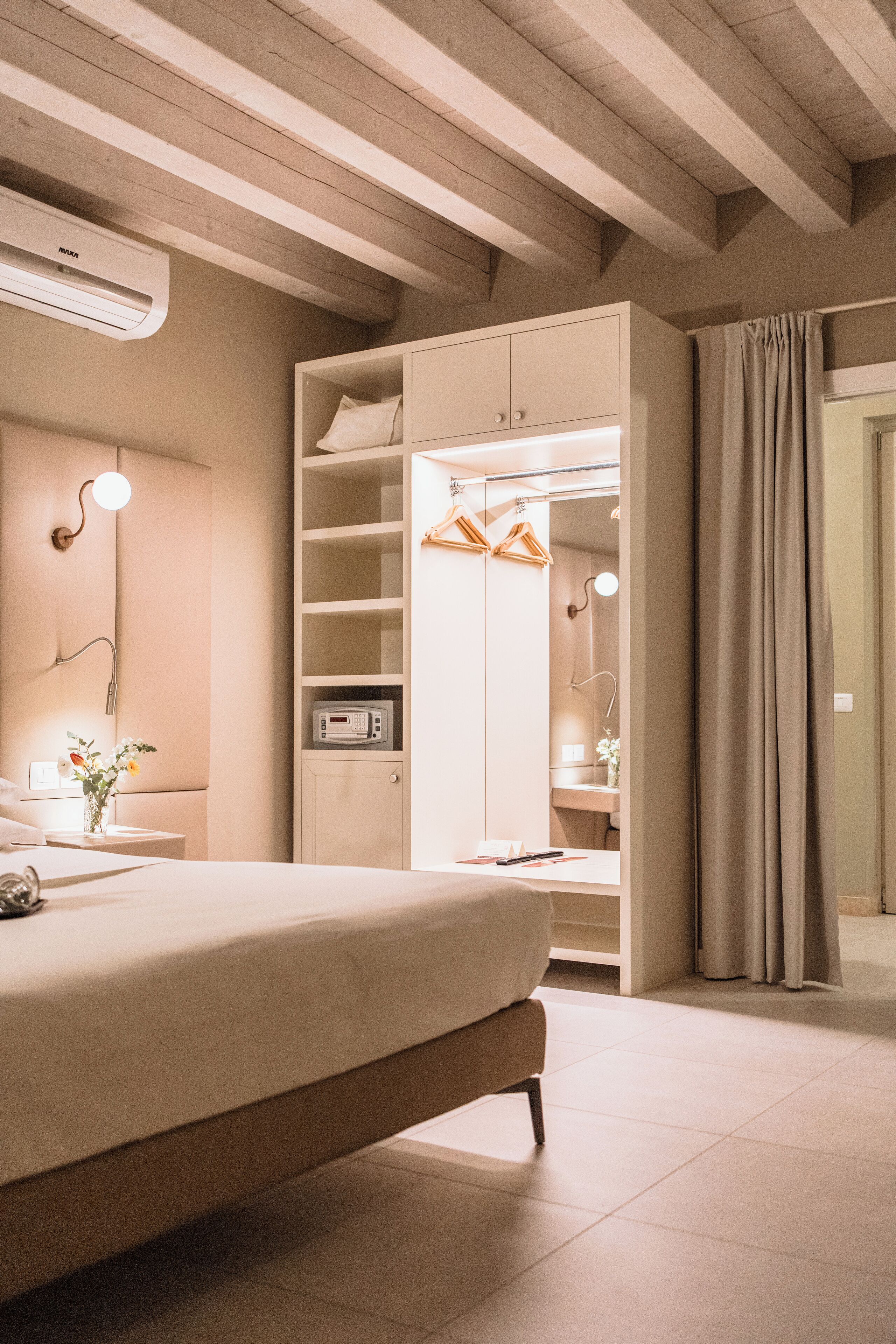 A bedroom with a bed, bedside table, and a wardrobe with hanging space.