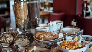 Une table de buffet proposant divers plats et accompagnements, notamment des bocaux de noix et un gâteau.