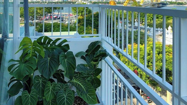 A balcony with a view of a city skyline, including a roller coaster and a bridge. - Corgi House - Steps from Dragon Bridge (Da Nang)