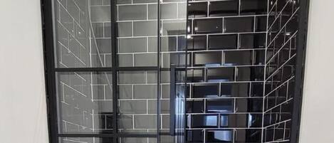 Une salle de bain avec une douche à parois de verre, des toilettes et un lavabo.