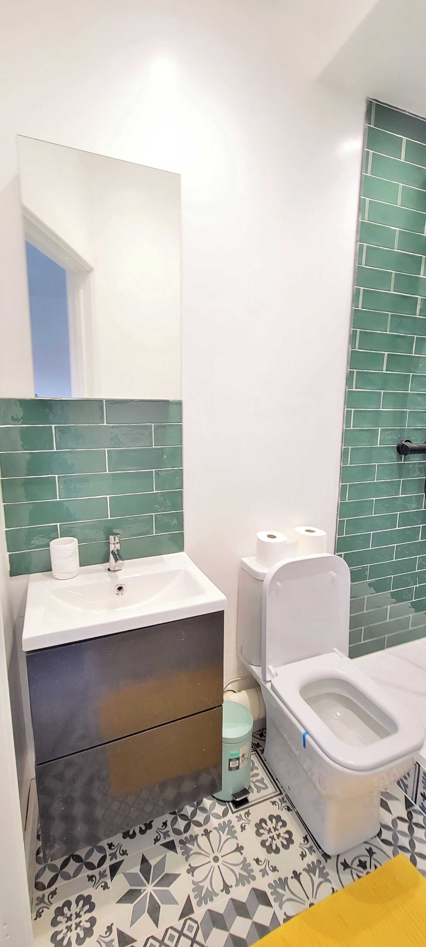 A bathroom with a white sink, a toilet, and a mirror.