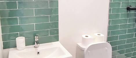 A bathroom with a white sink, a toilet, and a mirror.