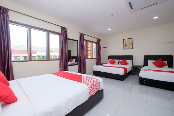 A hotel room with three beds, each with white and red bedding, and large windows with purple curtains. - OYO 1104 Q Hotel (Temerloh)