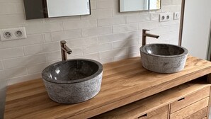 A bathroom vanity with two stone sinks, a wooden countertop, and a mirror above. - La Belle Fieffe - Garden, nature & peace (Vire Normandie)
