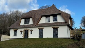 A two-story house with a steeply pitched roof, white exterior walls, and a small front porch. - La Belle Fieffe - Garden, nature & peace (Vire Normandie)