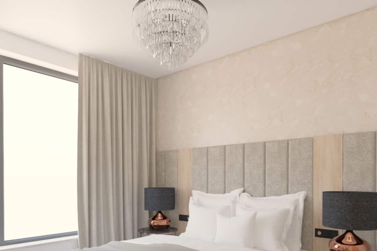 Een moderne hotelkamer met een groot bed, een kroonluchter en uitzicht op de stad.